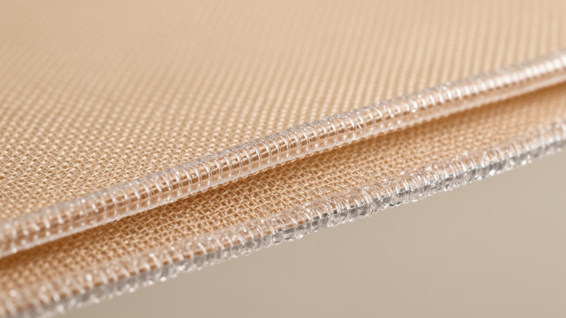 Macro view of an edge-bonded seam — two layers of mesh fused with a clear bond line